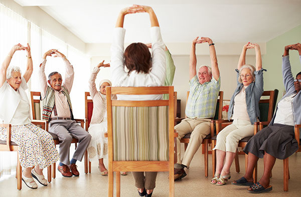 Daily stretching exercise routine for a group of cheerful elderly people at an old age home